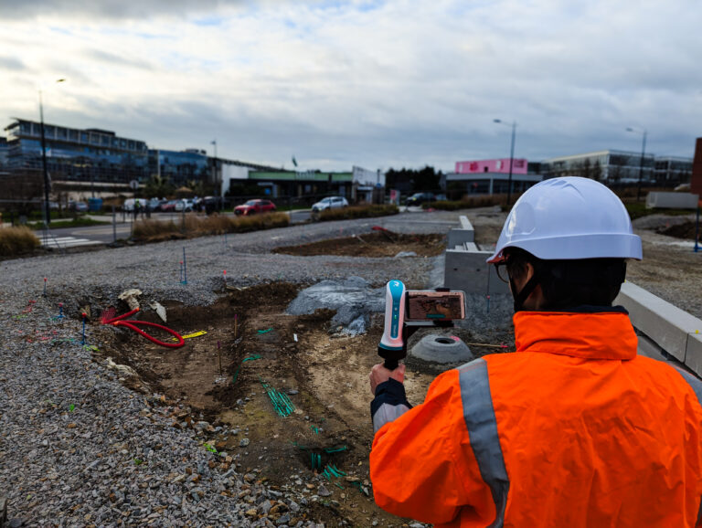 Homme sur un chantier, réalisant une détection de réseaux en fouille ouverte avec la solution RAPHAL.