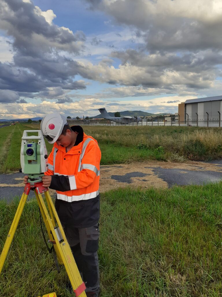 Service Topographie de GEOFIT Lyon Utilisation d'un tachéomètre pour prendre des mesures à l'aéroport, par le service Topographie