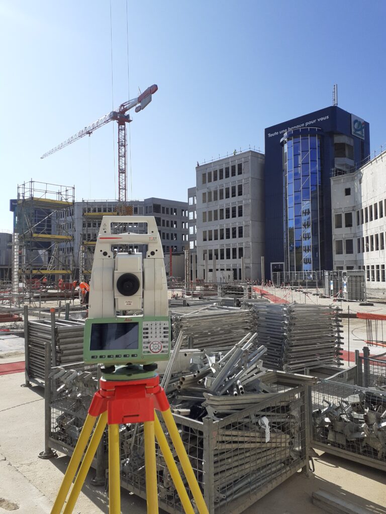 Photo projet, service BTP de GEOFIT Lyon Utilisation d'un tachéomètre pour aider à la construction d'un bâtiment, par l'équipe BTP