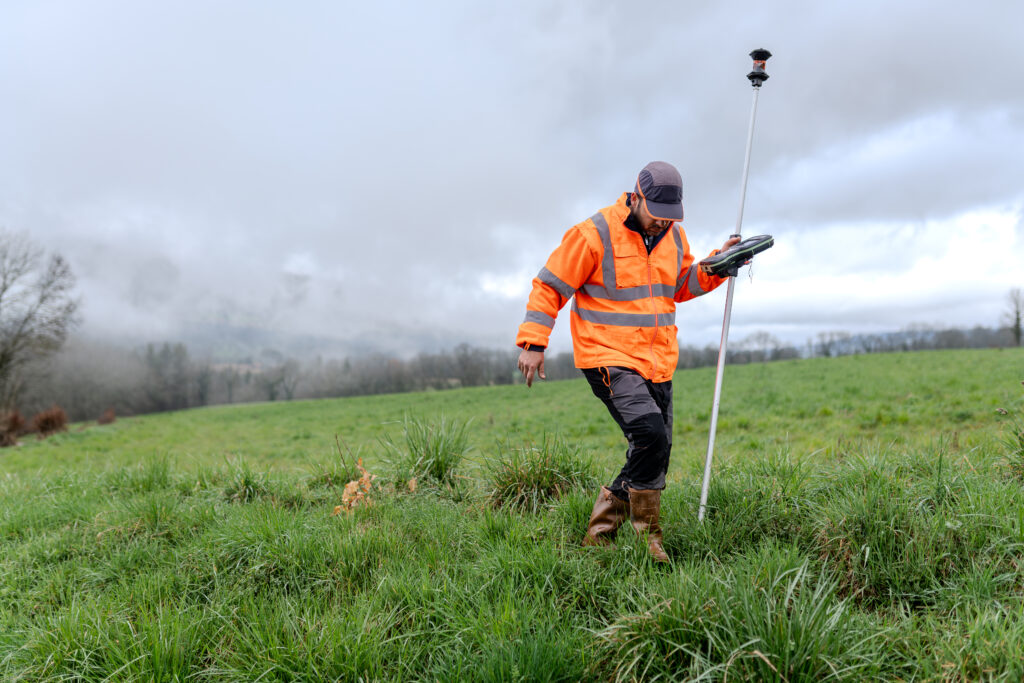 Geomètre Géomètre prenant des mesures sur le terrain